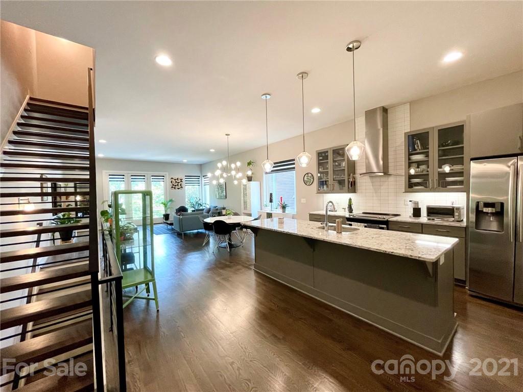 936 Westbrook Drive, Unit A Charlotte, NC 28202 - Photo 8 of 32 a kitchen with stainless steel appliances granite countertop a stove refrigerator and a wooden floor