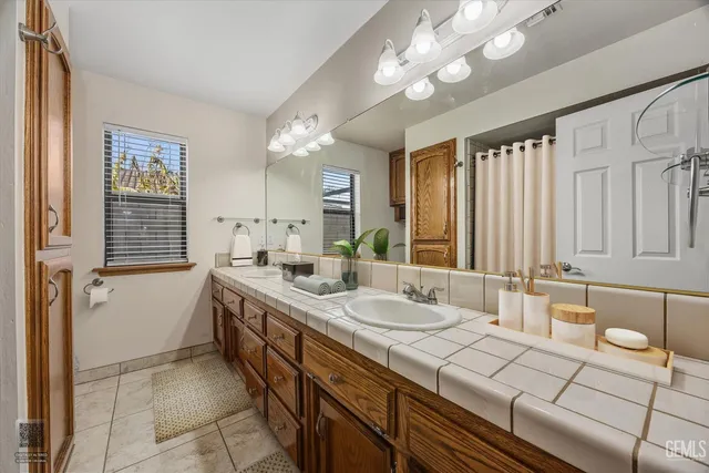 a spacious bathroom with a double vanity sink a mirror and a bathtub