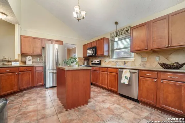 a kitchen with stainless steel appliances granite countertop a stove refrigerator and cabinets