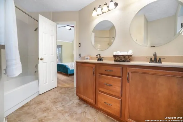 a bathroom with a double vanity sink mirror and shower