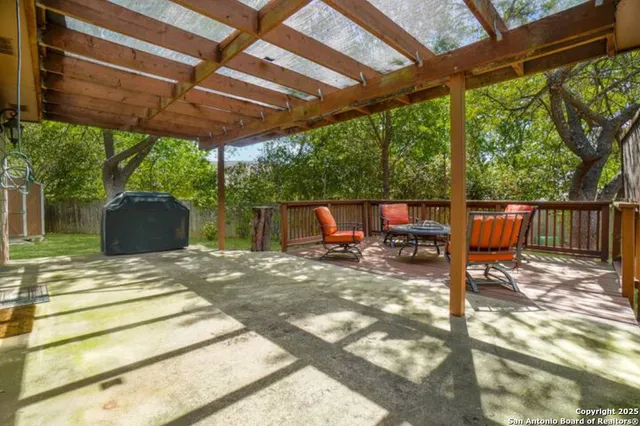 a view of backyard with table and chairs and wooden fence