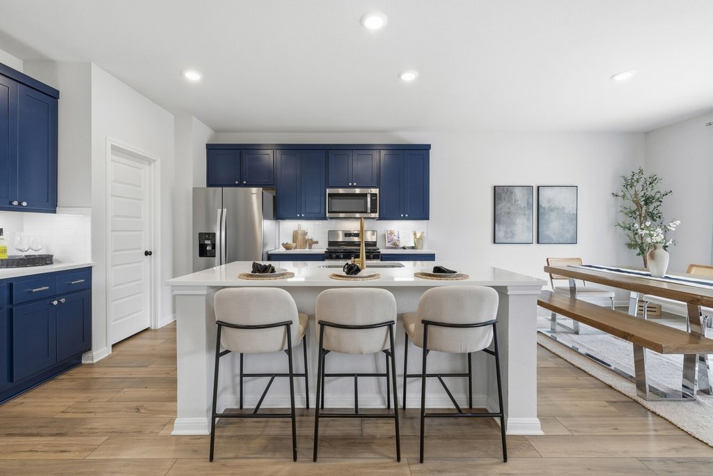 8001 Andravida Drive Austin, TX 78747 - Photo 11 of 35 Kitchen featuring blue cabinetry, a kitchen bar, decorative backsplash, a kitchen island with sink, and recessed lighting