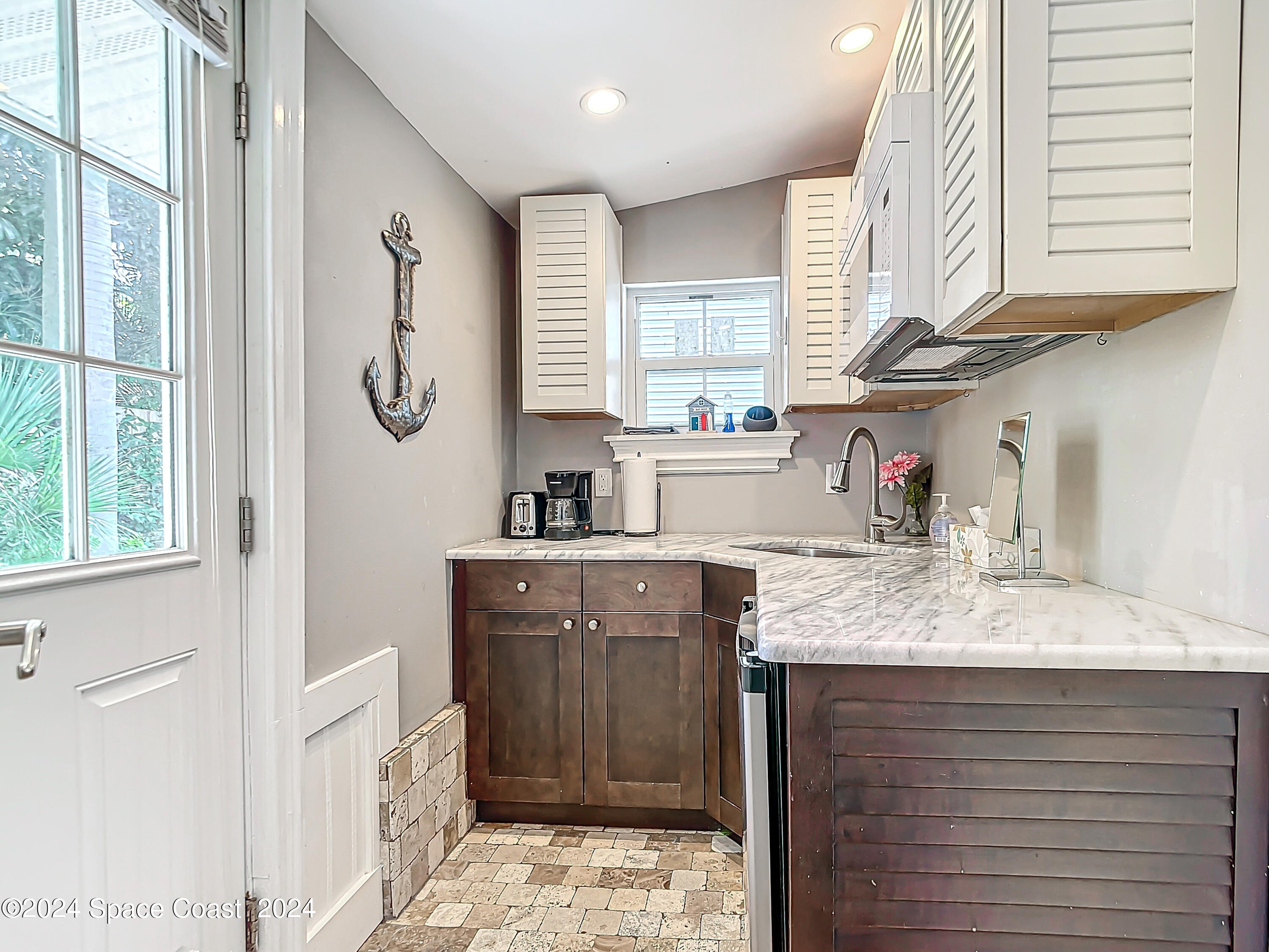 230 Rita Boulevard Melbourne Beach, FL 32951 - Photo 24 of 36 a kitchen with a sink cabinets and a window