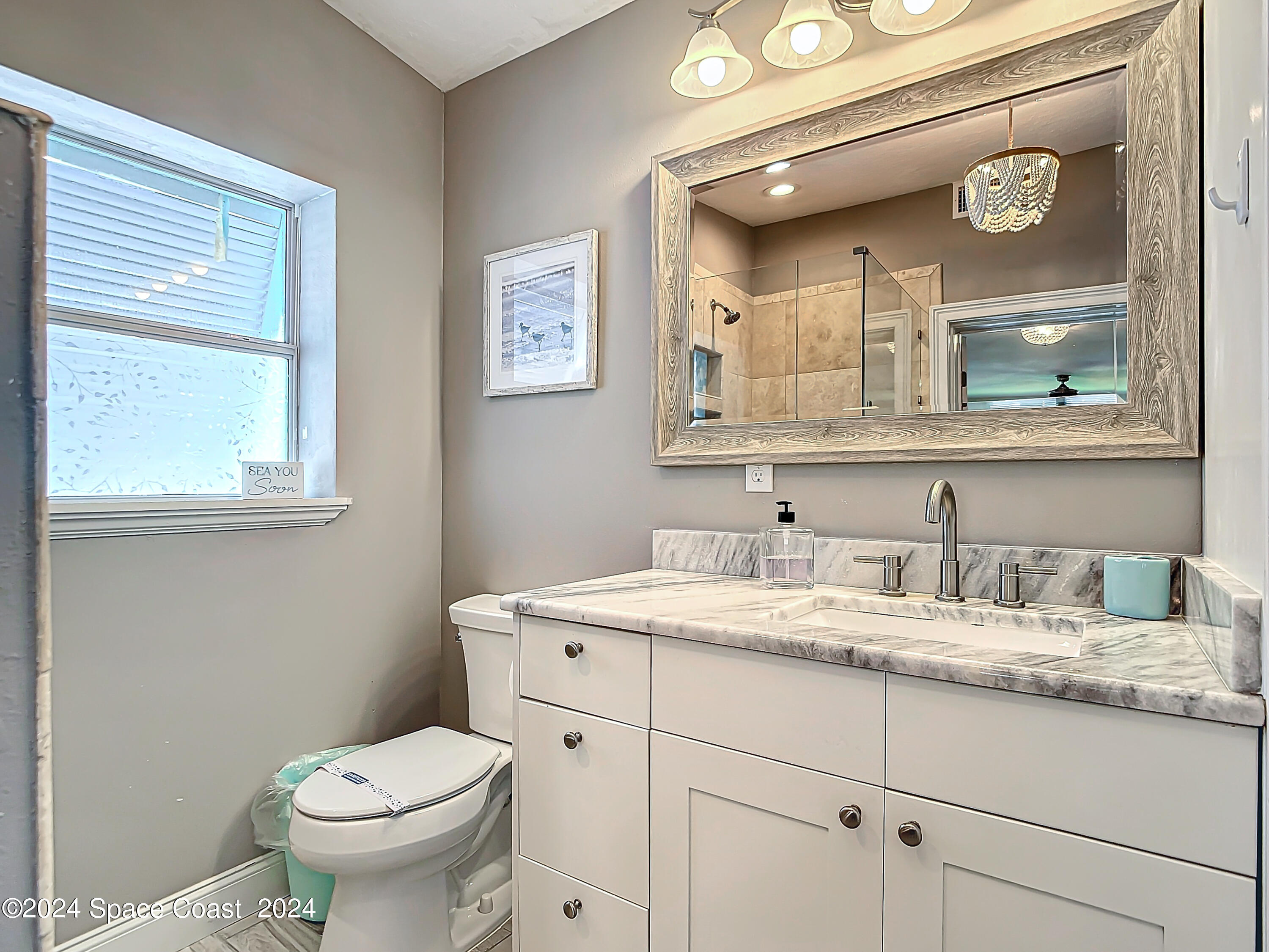 230 Rita Boulevard Melbourne Beach, FL 32951 - Photo 30 of 36 a bathroom with a toilet sink and mirror