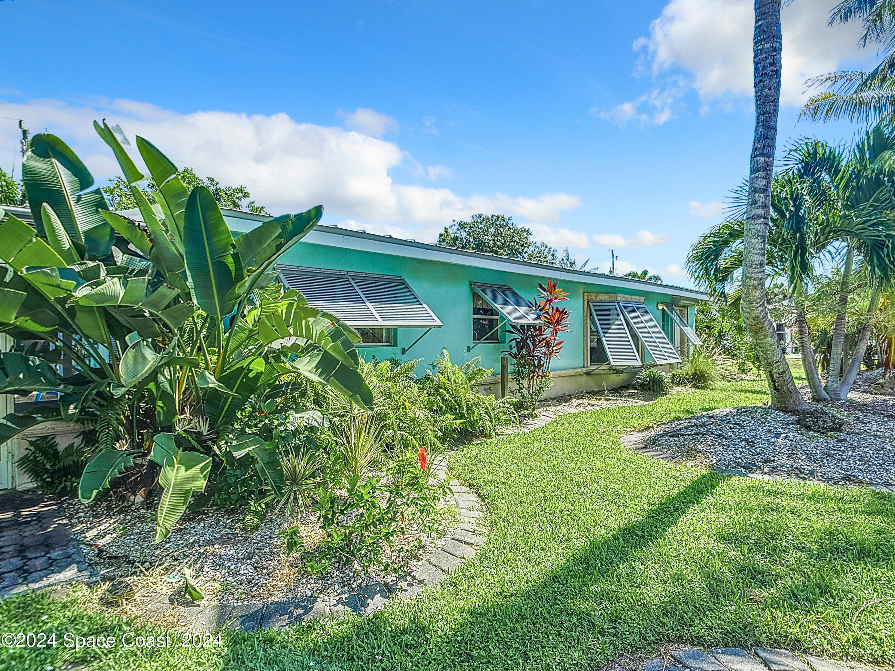 230 Rita Boulevard Melbourne Beach, FL 32951 - Photo 6 of 36 a yellow and red house with a garden