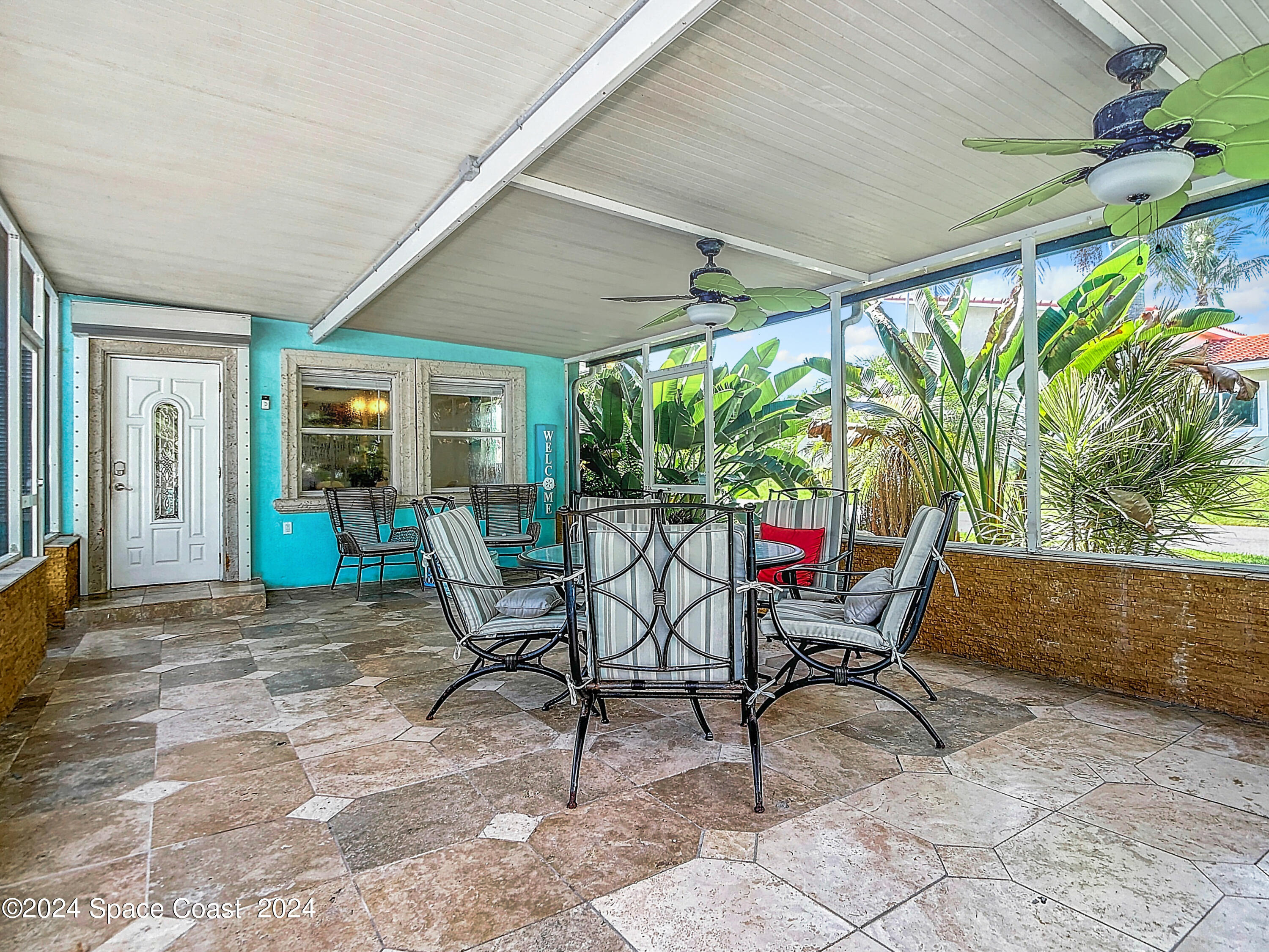230 Rita Boulevard Melbourne Beach, FL 32951 - Photo 7 of 36 a view of a patio with table and chairs and potted plants