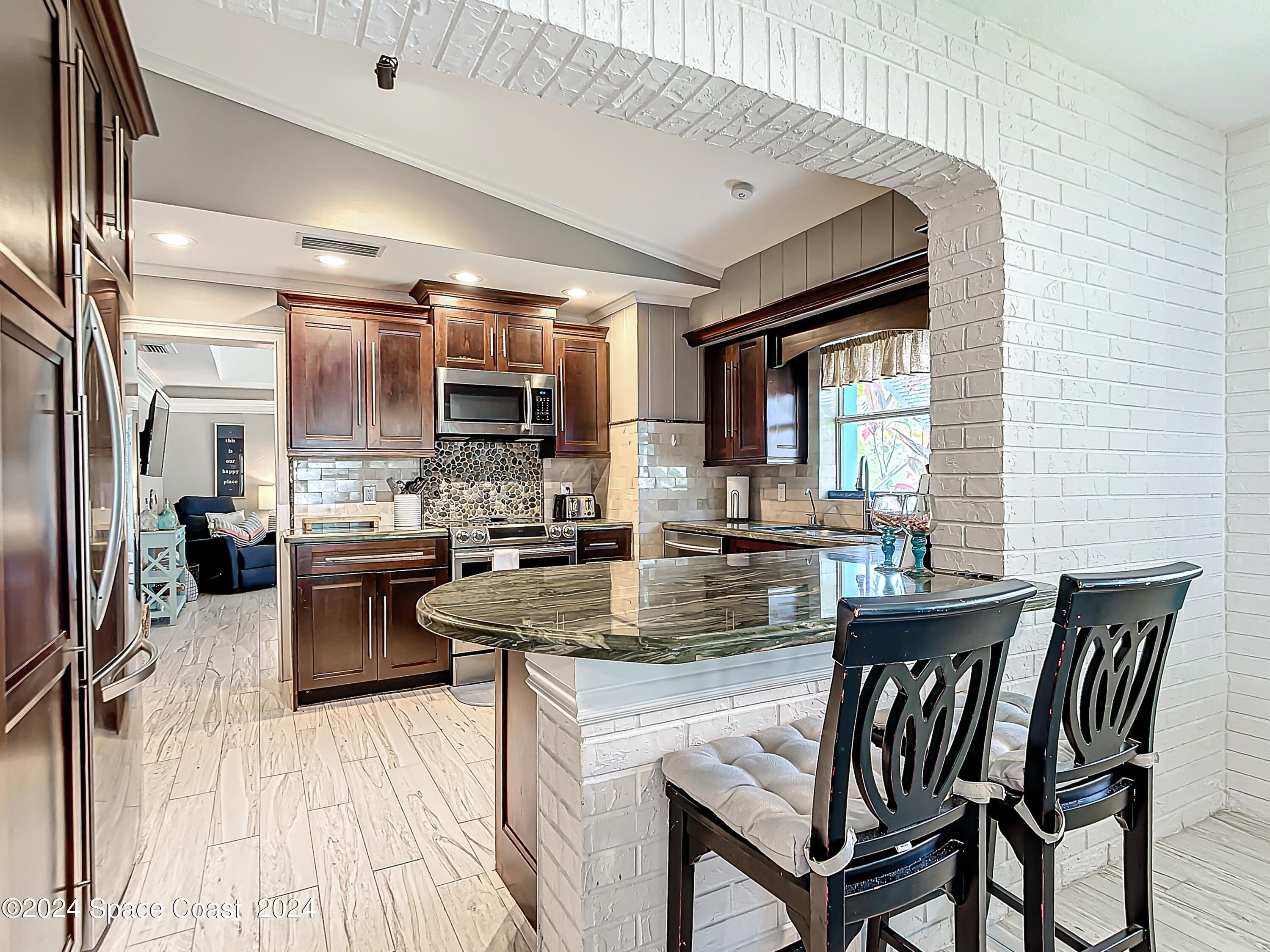 230 Rita Boulevard Melbourne Beach, FL 32951 - Photo 10 of 36 a kitchen with a table chairs refrigerator and cabinets
