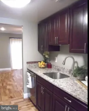 a kitchen with granite countertop a sink a stove and cabinets