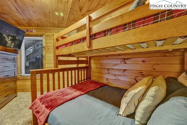 a bedroom with a bed next to a window