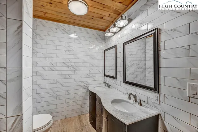a bathroom with a sink mirror vanity and toilet