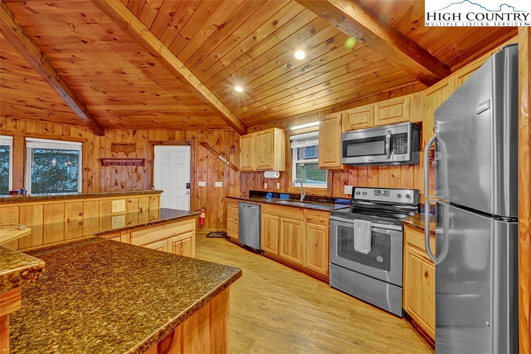 127 Skiloft Road Beech Mountain, NC 28604 - Photo 6 of 42 a kitchen with stainless steel appliances granite countertop a sink a stove top oven a chimney and a refrigerator