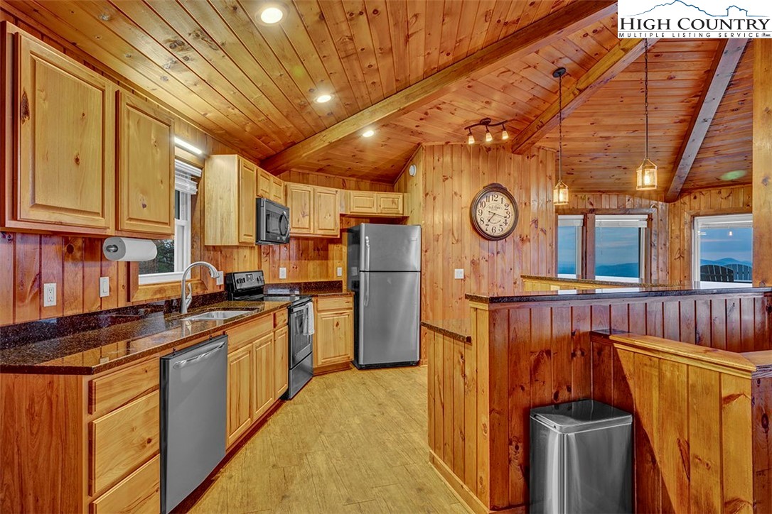 127 Skiloft Road Beech Mountain, NC 28604 - Photo 7 of 42 a kitchen with stainless steel appliances granite countertop a stove a refrigerator a sink and dishwasher with wooden floor