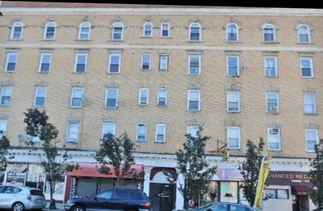 a building view with couple of cars parked in front of it