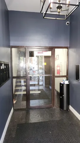 a view of a refrigerator in kitchen and an empty room