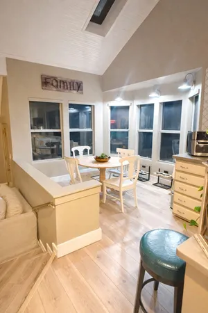 a living room with furniture a flat screen tv and kitchen view