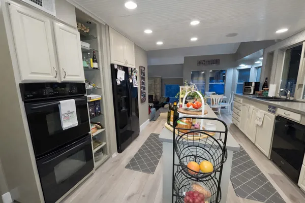 a view of a kitchen with stainless steel appliances granite countertop a refrigerator and a sink