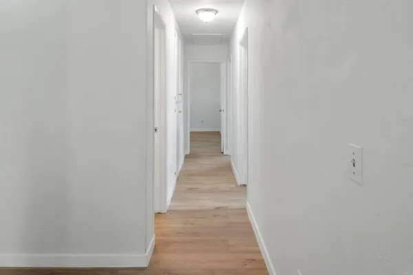 a view of a hallway with wooden floor