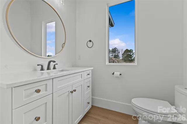 a dining hall with stainless steel appliances granite countertop a sink a oven and a refrigerator with wooden floor