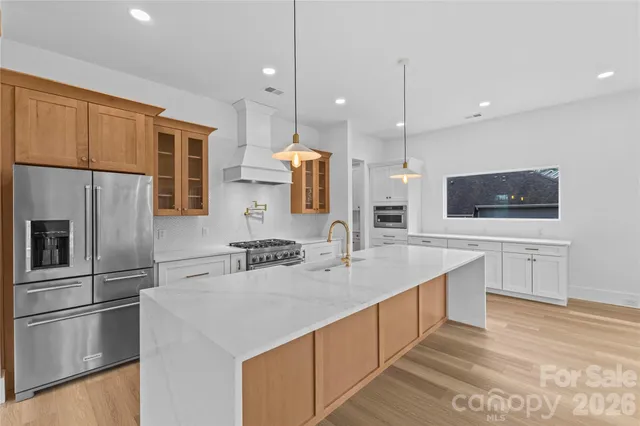 a kitchen with stainless steel appliances granite countertop a stove and a large window