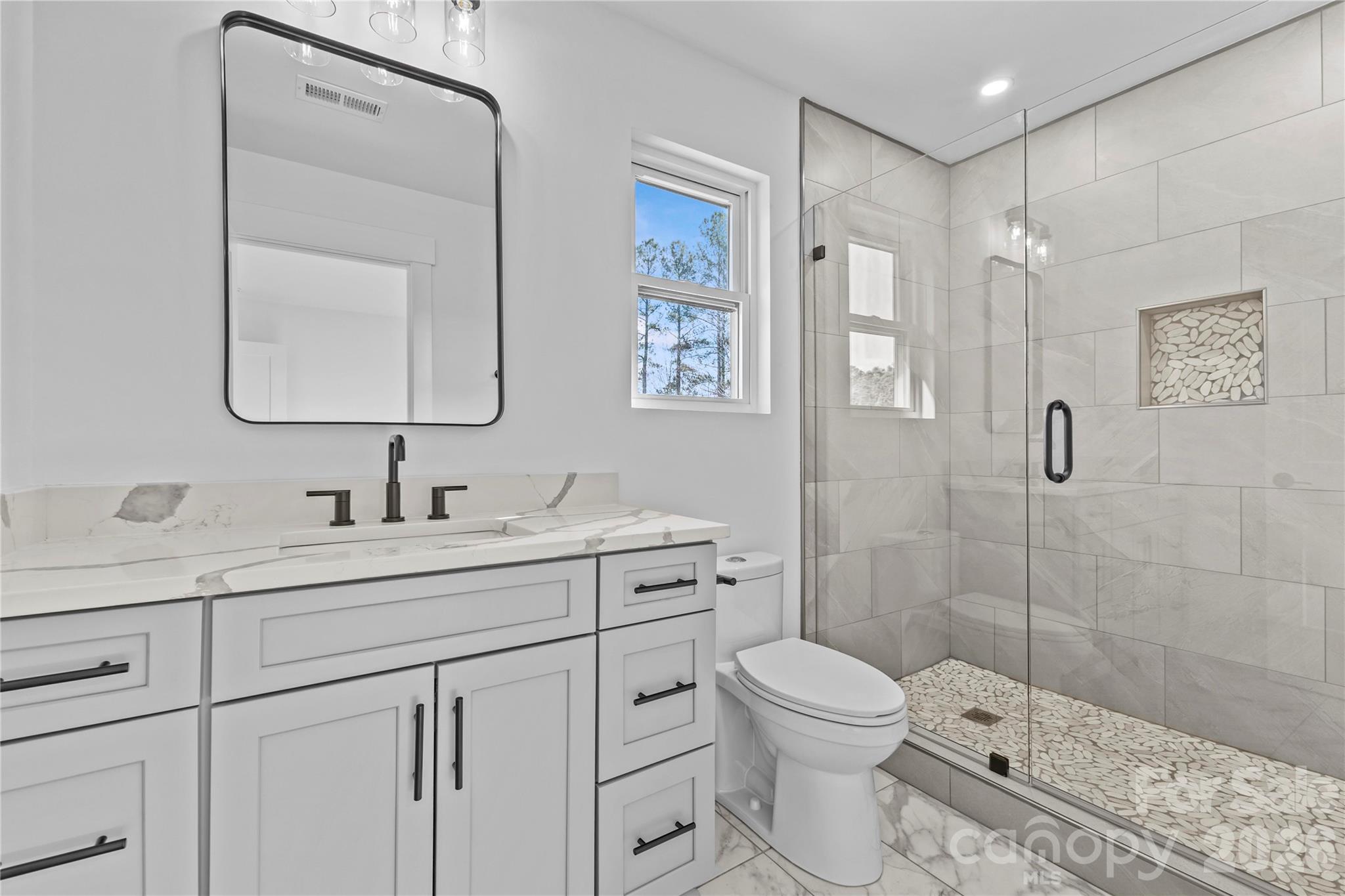 7362 Hemlock Court Denver, NC 28037 - Photo 33 of 46 a bathroom with a toilet sink vanity granite and shower