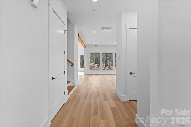 a view of a hallway with wooden floor and staircase