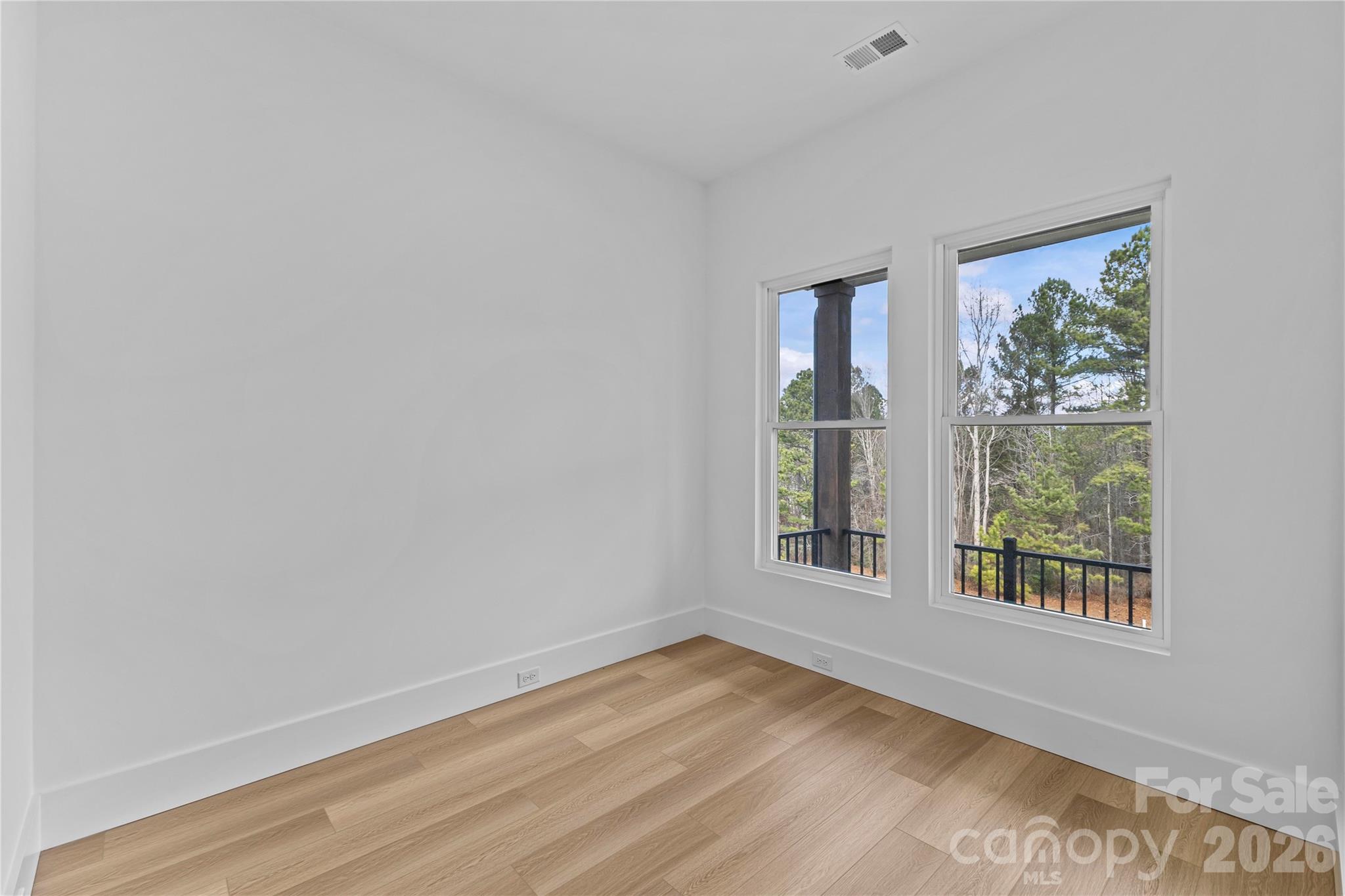 7362 Hemlock Court Denver, NC 28037 - Photo 7 of 46 a view of an empty room with wooden floor and a window