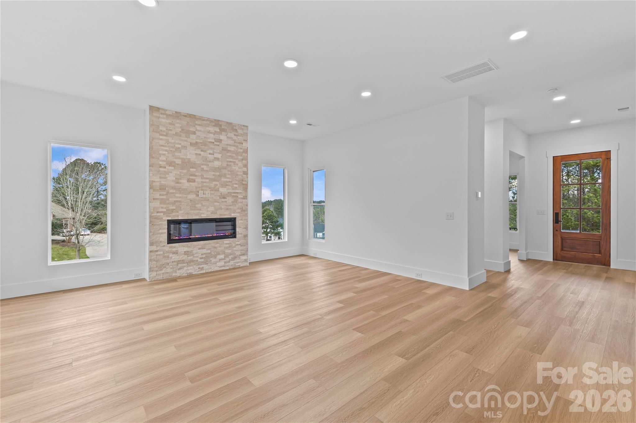 7362 Hemlock Court Denver, NC 28037 - Photo 10 of 46 an empty room with wooden floor fireplace and windows
