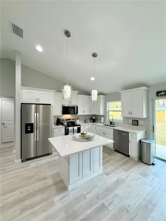 a large kitchen with a center island and stainless steel appliances