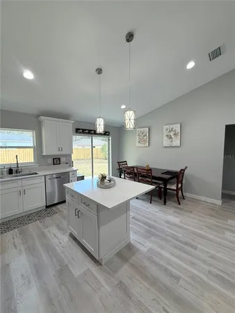 a kitchen with sink cabinets and wooden floor