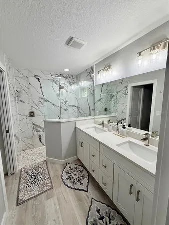 a spacious bathroom with double vanity and a mirror