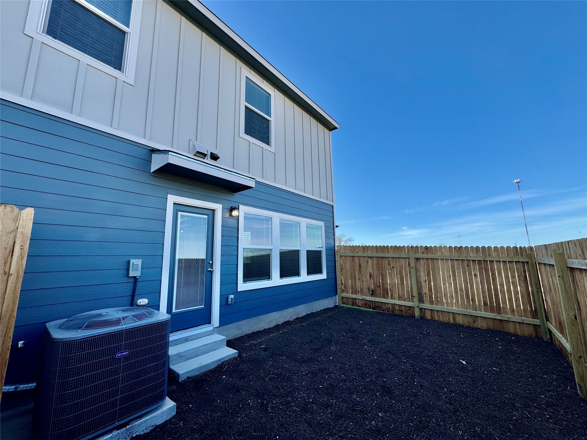 105 Calcite Road, Unit 1 Kyle, TX 78640 - Photo 5 of 7 Back of house featuring a fenced backyard, board and batten siding, and entry steps