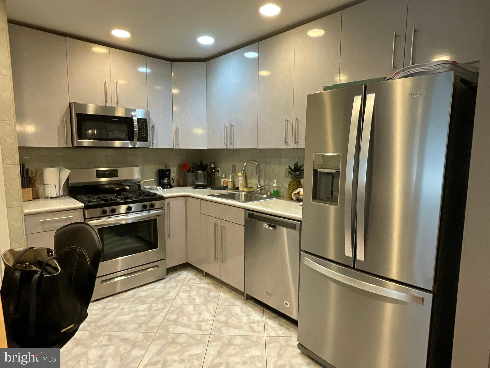 a kitchen with a refrigerator a microwave a sink and cabinets