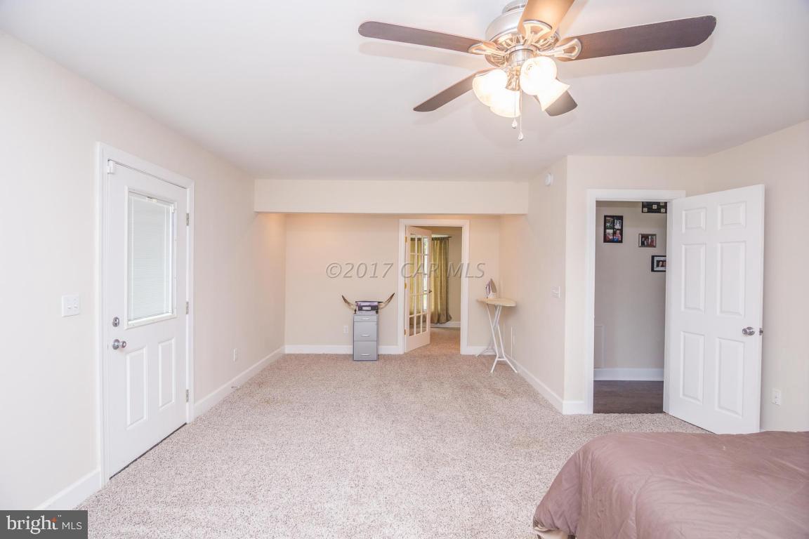 29632 Deal Island Road Princess Anne, MD 21853 - Photo 26 of 33 a bedroom with a bed and a chandelier