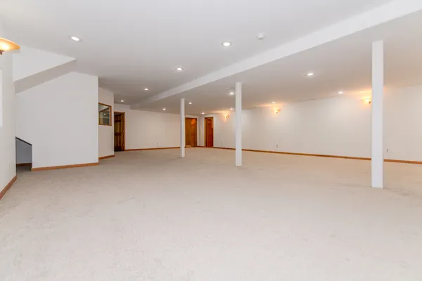 an empty room with a window and a projector screen