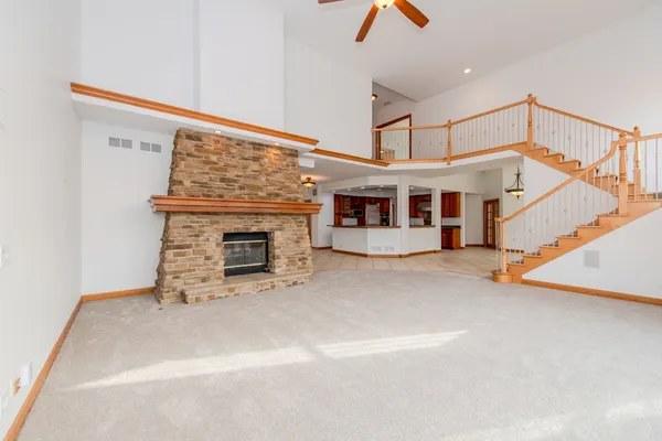 a view of a livingroom with fireplace stairs and windows