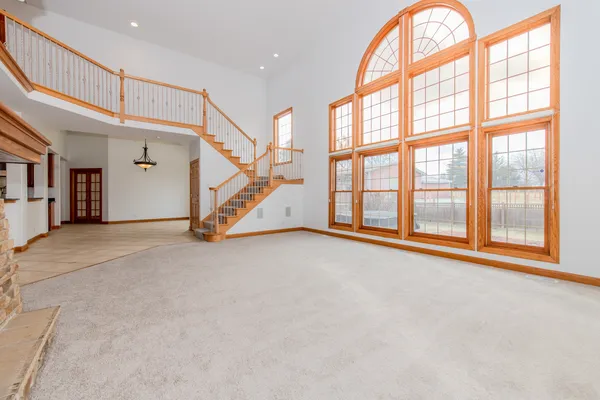 an empty room with wooden floor windows and a ceiling fan