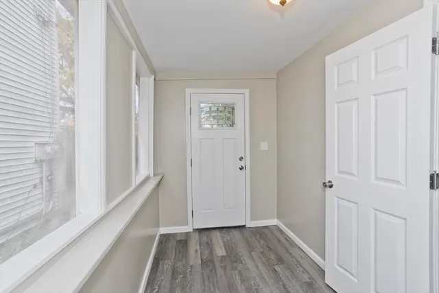 a view of a hallway with wooden floor and entryway