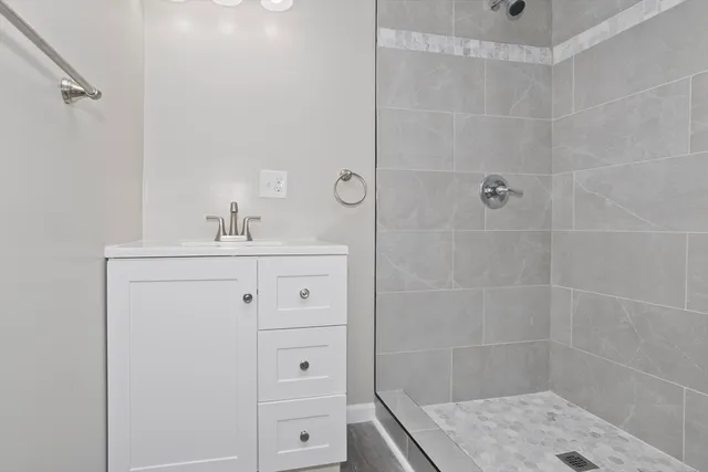 a bathroom with a sink shower and a mirror