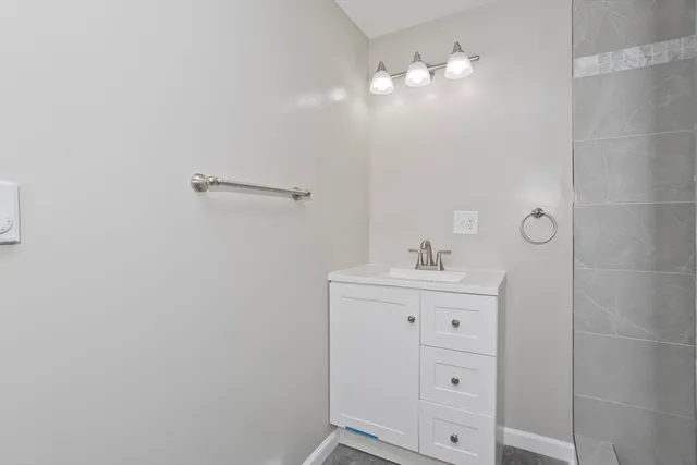a bathroom with a sink a light fixture and a mirror