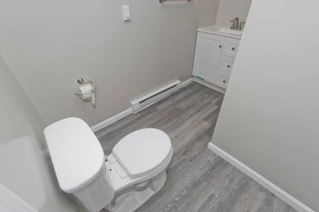a bathroom with a toilet mirror and vanity