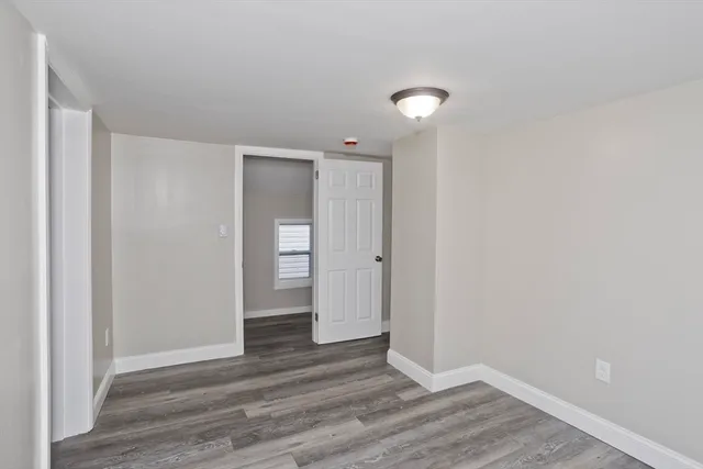 a view of an empty room with wooden floor and closet