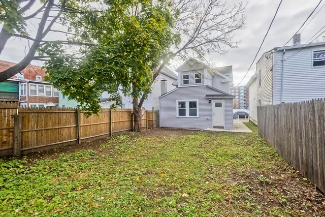a white house that has tree in front of it