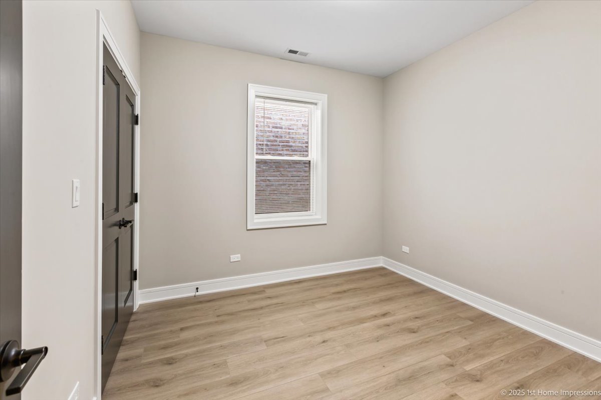 4932 South Champlain Avenue Chicago, IL 60615 - Photo 14 of 27 an empty room with wooden floor and windows