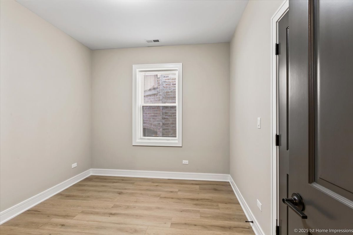 4932 South Champlain Avenue Chicago, IL 60615 - Photo 15 of 27 an empty room with wooden floor and windows