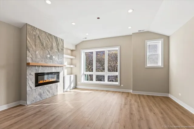 wooden floor fireplace and windows in an empty room