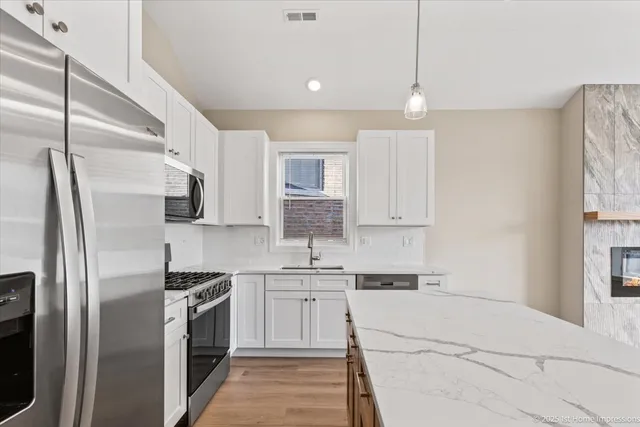 a kitchen with stainless steel appliances a refrigerator sink and cabinets