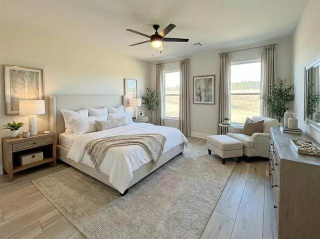 a spacious bedroom with a bed couch and window