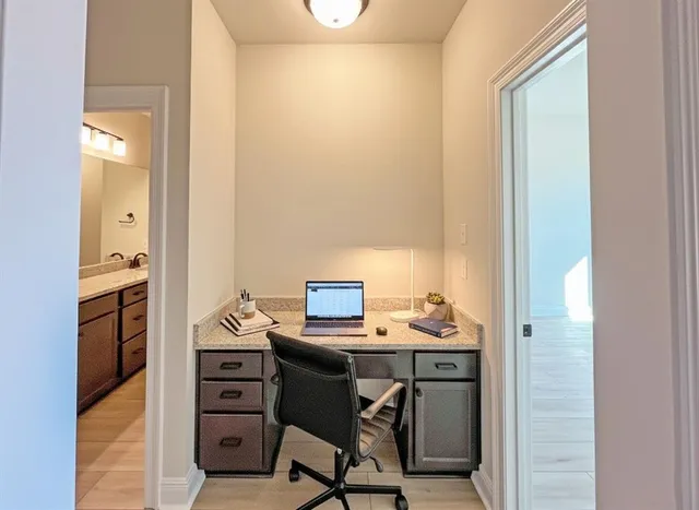 a view of a workspace with furniture and a window