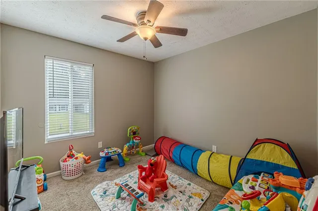 a living room with baby crib furniture and a window