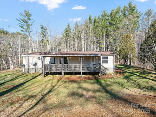 a view of a house with a wooden deck and a big yard